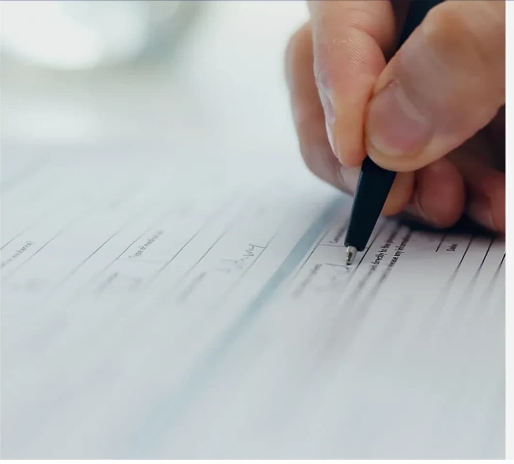 Hand completing federal grant documentation with a pen