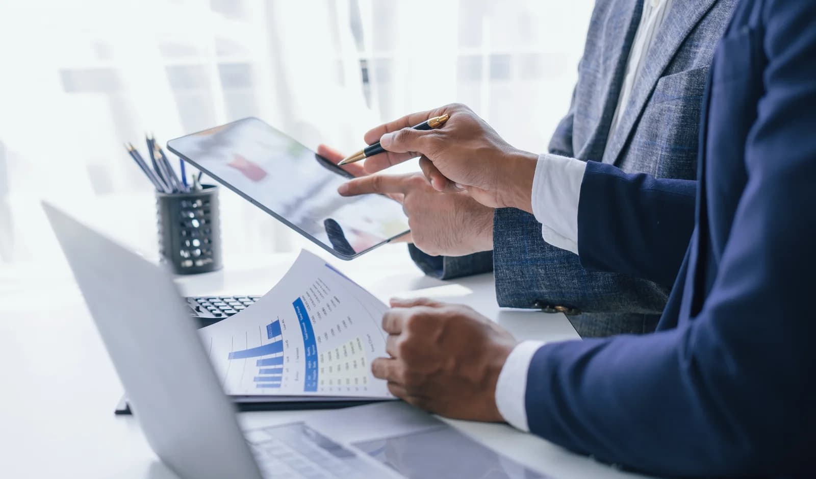 Business professionals reviewing financial charts and a tablet